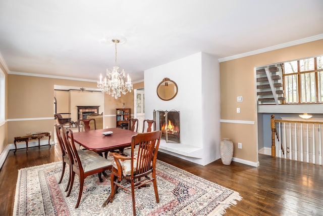594 Barrack Hill Rd, Ridgefield, CT 06877 - dining room featuring a warm lit fireplace, wood finished floors, ornamental molding, a chandelier, and baseboards