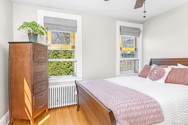 bedroom with light wood-style floors and radiator