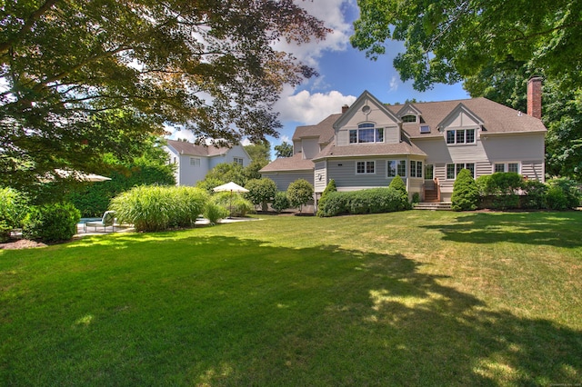 view of front of house with a chimney and a front lawn