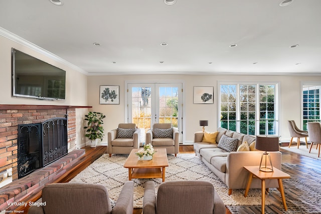 living area featuring a fireplace, ornamental molding, a wealth of natural light, and wood finished floors