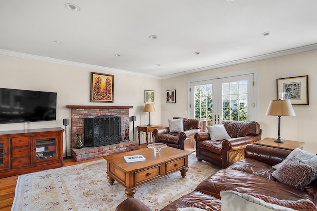 living room featuring french doors, ornamental molding, a brick fireplace, and wood finished floors