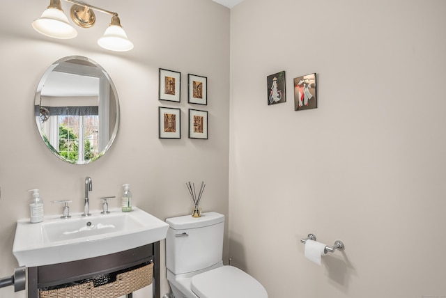 half bathroom featuring vanity and toilet