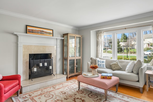 living area with crown molding, wood finished floors, and a high end fireplace