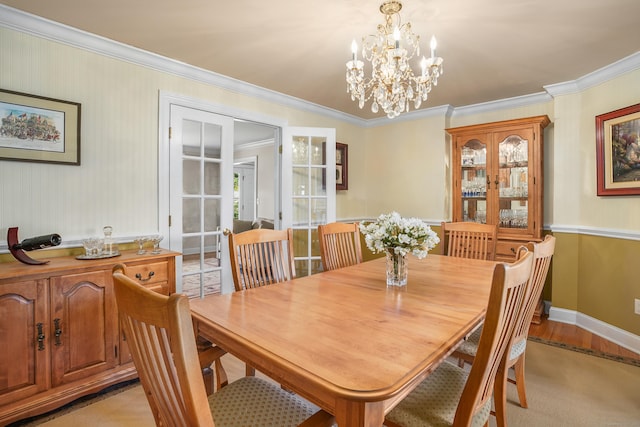 dining space featuring crown molding, baseboards, light wood finished floors, and a chandelier