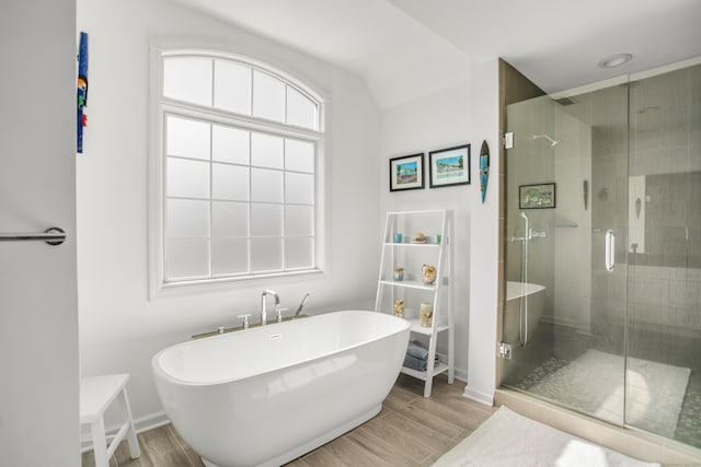 full bathroom featuring a freestanding tub, wood finished floors, and a shower stall