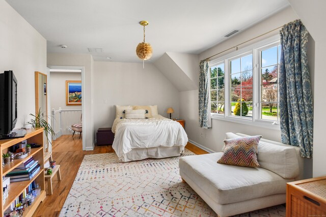 bedroom featuring baseboards, wood finished floors, and visible vents