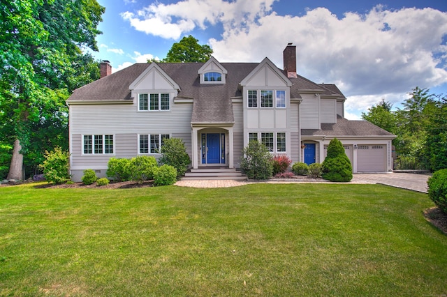 view of front of property featuring a chimney, decorative driveway, a front lawn, an attached garage, and a shingled roof