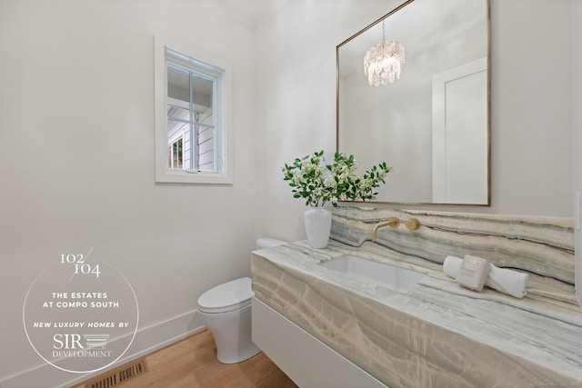 104 Compo Rd S, Westport, CT 06880 - half bath with an inviting chandelier, toilet, wood finished floors, visible vents, and vanity