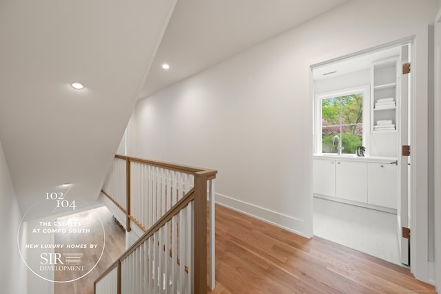 104 Compo Rd S, Westport, CT 06880 - corridor with light wood-style flooring, recessed lighting, baseboards, a sink, and an upstairs landing
