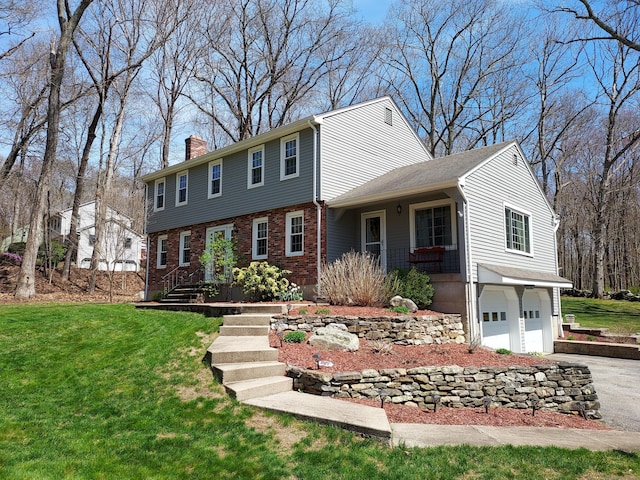 43 Attawanhood Trl, Hebron, CT 06231 - colonial inspired home with a front yard, a garage, a chimney, driveway, and brick siding