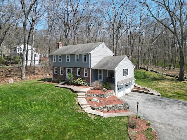 43 Attawanhood Trl, Hebron, CT 06231 - colonial home with a chimney, aphalt driveway, a front lawn, brick siding, and a garage