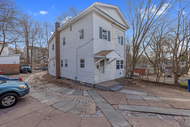 rear view of property with fence and a chimney