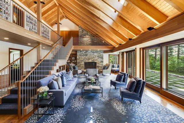 living room featuring beamed ceiling, wood finished floors, stairs, wood ceiling, and high vaulted ceiling