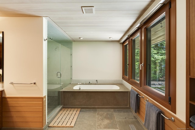 bathroom with a garden tub, visible vents, and a shower stall
