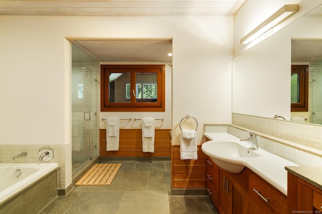 full bath featuring a bath, vanity, and a stall shower