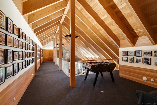rec room with wood ceiling, vaulted ceiling with beams, wooden walls, and carpet flooring