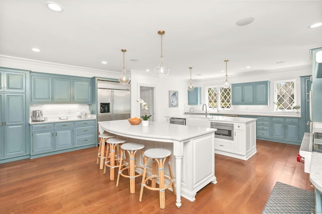 47 Peaceable St, Ridgefield, CT 06877 - kitchen featuring a kitchen island, ornamental molding, backsplash, appliances with stainless steel finishes, and light countertops