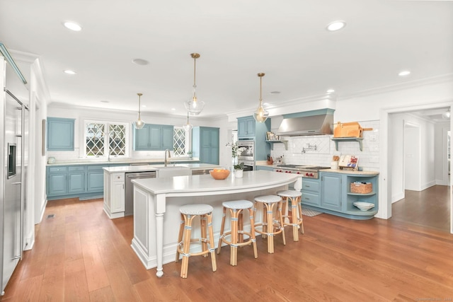 47 Peaceable St, Ridgefield, CT 06877 - kitchen featuring blue cabinets, a center island with sink, open shelves, appliances with stainless steel finishes, and decorative backsplash