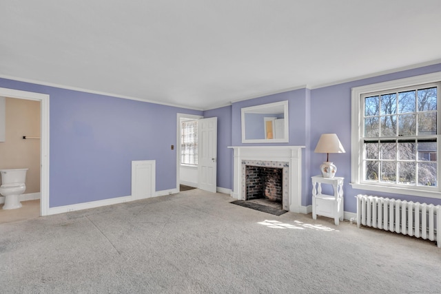 unfurnished living room featuring carpet flooring, baseboards, radiator heating unit, crown molding, and a fireplace