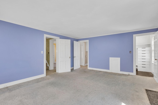 unfurnished bedroom with baseboards, carpet, and crown molding