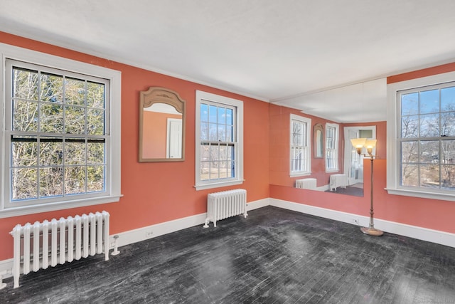 unfurnished room featuring radiator and baseboards