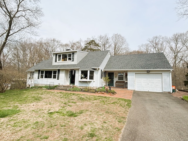 view of front of home featuring a front lawn, a garage, a shingled roof, aphalt driveway, and a chimney