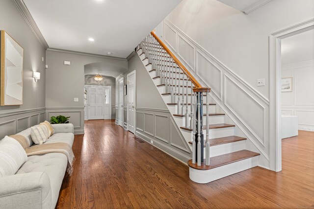 275 Newtown Tpke, Weston, CT 06883 - living room featuring a decorative wall, ornamental molding, wood finished floors, and stairs