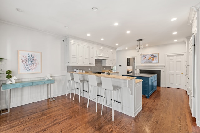 275 Newtown Tpke, Weston, CT 06883 - kitchen featuring dark wood finished floors, ornamental molding, premium range hood, a kitchen island, and a peninsula