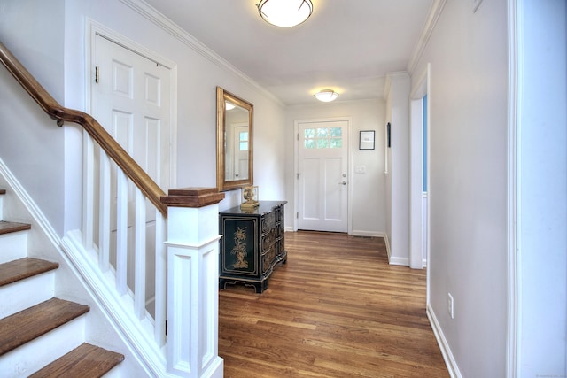 foyer entrance with baseboards, stairs, crown molding, and wood finished floors