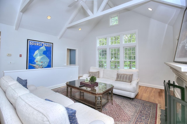 living room featuring plenty of natural light, beamed ceiling, and high vaulted ceiling