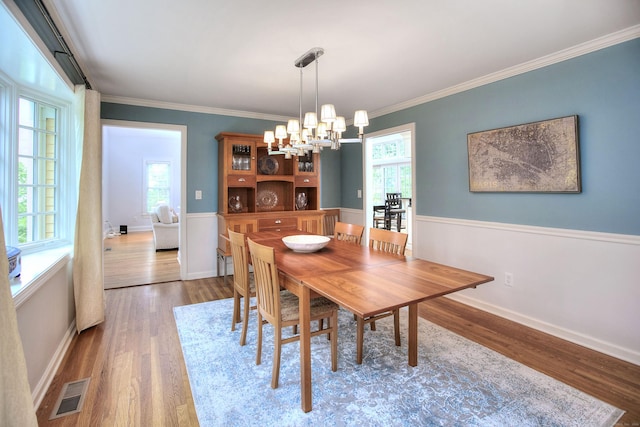 dining space with plenty of natural light, visible vents, and wood finished floors