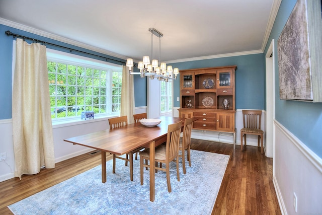 dining area featuring ornamental molding, a notable chandelier, and dark wood finished floors