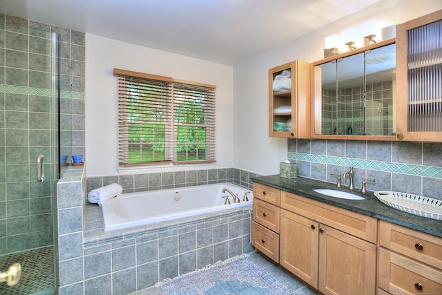 full bathroom featuring vanity, a stall shower, tile patterned flooring, decorative backsplash, and a garden tub