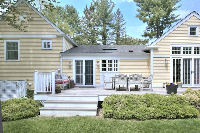 back of property with a deck, french doors, and a shingled roof
