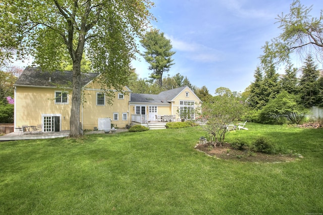 back of property featuring a yard, a patio area, and a wooden deck
