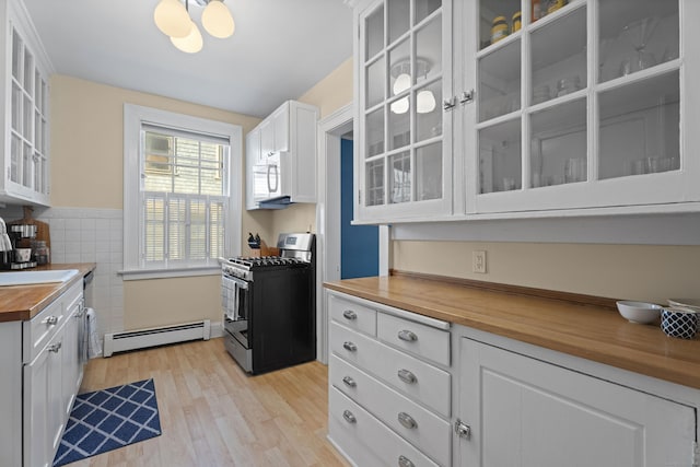 498 Whitney Ave Unit 1D, New Haven, CT 06511 - kitchen with butcher block countertops, gas range, a baseboard radiator, white microwave, and light wood-style flooring