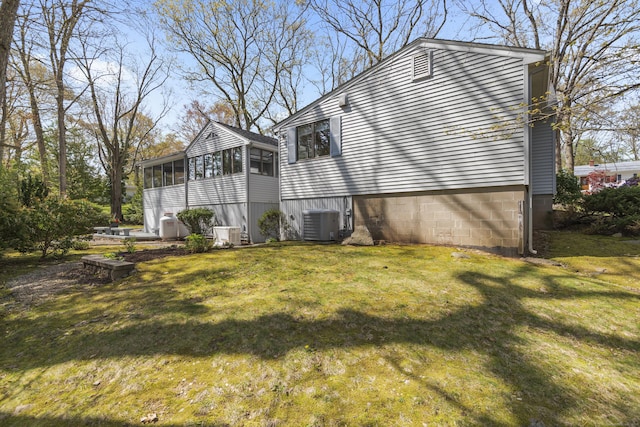 view of side of property with a yard, central AC unit, and a sunroom