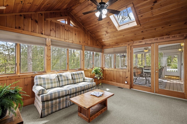 sunroom / solarium featuring carpet flooring, wood walls, visible vents, wood ceiling, and lofted ceiling with skylight