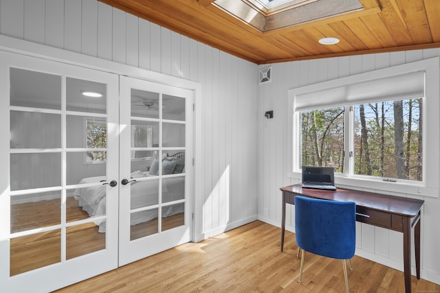 unfurnished office with wood ceiling, french doors, a skylight, wood walls, and wood finished floors
