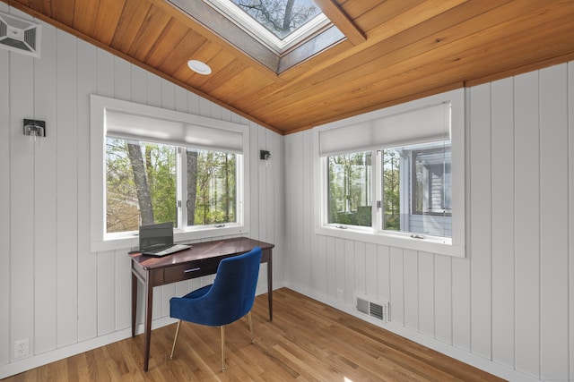 office area featuring visible vents, a wealth of natural light, lofted ceiling with skylight, and wood finished floors