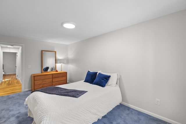 bedroom with baseboards and carpet