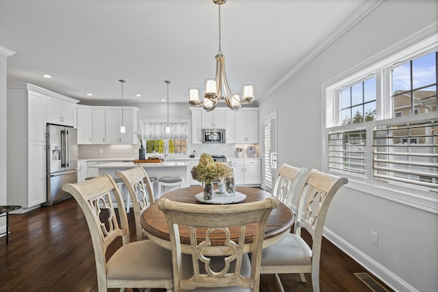 dining space with a healthy amount of sunlight, a notable chandelier, dark wood-style flooring, and visible vents