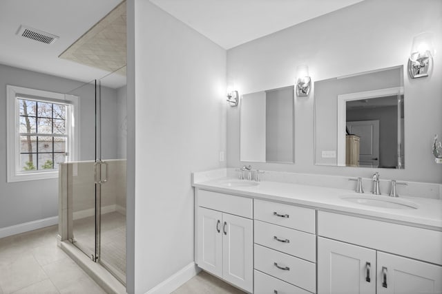 bathroom featuring visible vents, a sink, baseboards, and a stall shower