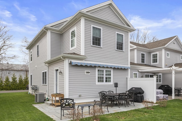 rear view of property featuring a yard, central AC, and a patio area