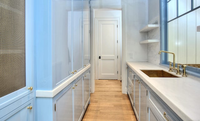 7 Brookside Dr, Westport, CT 06880 - kitchen featuring open shelves, a sink, light wood-style flooring, and light countertops