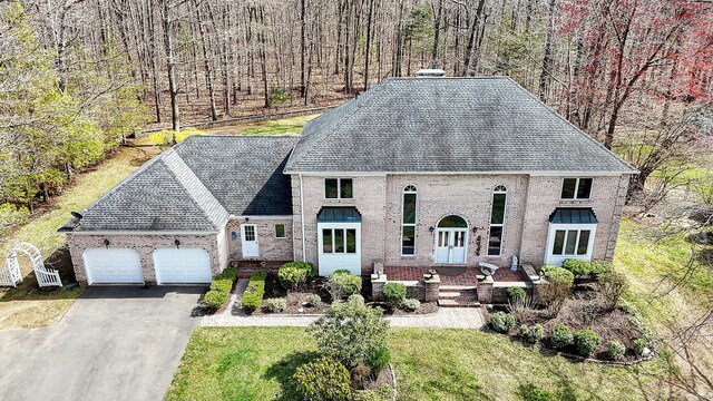 17 Hidden Oak Dr, Farmington, CT 06032 - french country home with a garage, asphalt driveway, a chimney, and brick siding