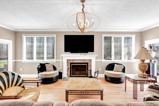 17 Hidden Oak Dr, Farmington, CT 06032 - living area featuring wood finished floors, a chandelier, ornamental molding, a textured ceiling, and a high end fireplace