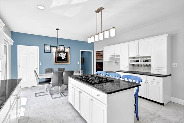 17 Hidden Oak Dr, Farmington, CT 06032 - kitchen featuring black gas cooktop, light marble finish floors, a kitchen bar, a chandelier, and a center island