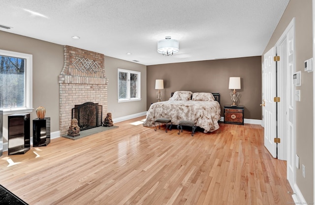 17 Hidden Oak Dr, Farmington, CT 06032 - bedroom featuring light wood-style flooring, a fireplace, a textured ceiling, and recessed lighting
