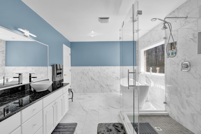 17 Hidden Oak Dr, Farmington, CT 06032 - full bath with vanity, marble look tiles, tile walls, a marble finish shower, and a wainscoted wall